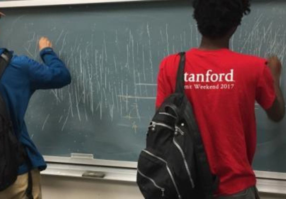 Student writing on chalk board